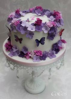 a white cake with purple and pink flowers on it