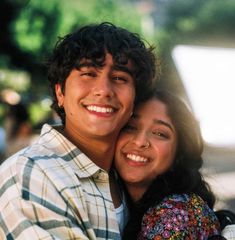 a young man and woman hugging each other