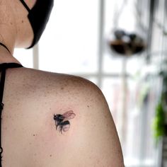 a woman with a bee tattoo on her back