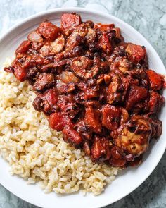 a white plate topped with rice and meat