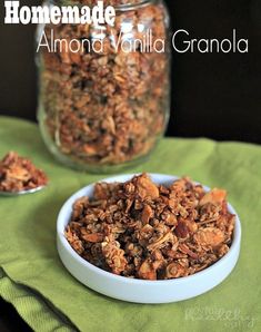 homemade almond vanilla granola in a white bowl on a green napkin next to a glass jar