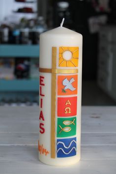 a white candle with colorful designs on it