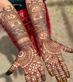 two hands with henna tattoos on them