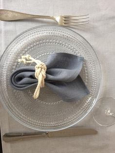 a glass plate topped with a napkin and fork