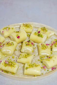 there are many small pieces of food on the white plate with green sprinkles