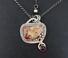 This one-of-a-kind sterling silver necklace features an asymmetrical crazy lace agate stone, with a deep red garnet cabochon and 9 ct gold accents, on an oxidised chain.  This pendant would make a unique gift (for someone else or yourself and is ready to ship within 2 days of ordering. ⚙️Details: ~ The pendant measures approximately 30 mm wide and 40 mm long (from bail rings to bottom of garnet). ~ Lace agate stone size: 24 mm x 17 mm; garnet 6 mm. ~ The sliver bezel is surrounded by a hand stam Garnet Necklace Silver, Art Jewelry Necklace, Bold Jewelry, Agate Jewelry, Crazy Lace Agate, Agate Necklace, Work Jewelry, Lace Agate, Agate Pendant