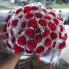 a bouquet made out of rolled up money is being held by someone's hand