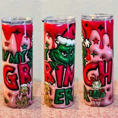 three red and green tumblers sitting on top of a table next to each other