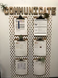 a bulletin board with clipboards attached to it and the word communicate written on it