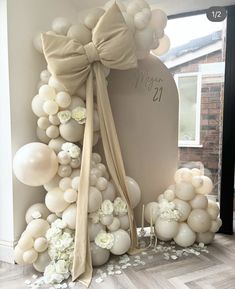 a balloon arch with balloons and flowers on it