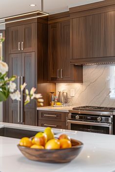 a bowl of fruit sitting on top of a counter next to a stove and oven