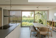 a dining room table and chairs in front of an open window