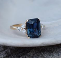 a ring with a blue stone surrounded by three diamonds