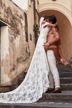 a bride and groom kissing on the steps