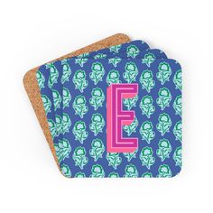 two coasters with the letter e in pink, blue and green floral designs on them