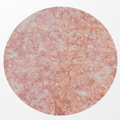 a round marble table top on a white surface with an orange and pink color scheme