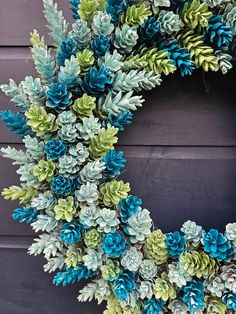 a wreath made out of blue and green pine cones