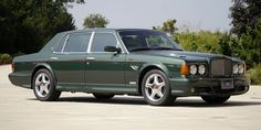 a green station wagon parked in a parking lot