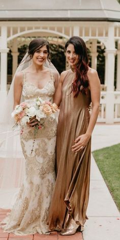 two women standing next to each other in dresses