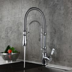 a stainless steel kitchen sink with faucet and strainer in the middle, next to a bowl of vegetables