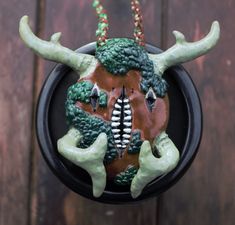 a ceramic sculpture of a demon with horns on it's head and two hands