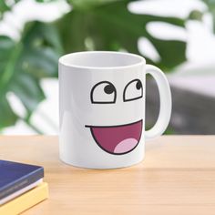 a white coffee mug with an emoticive face on it sitting on a table