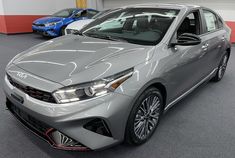 a silver car parked in a garage next to other cars