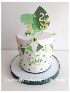 a birthday cake with a dinosaur on top and number two in the middle, sitting on a plate