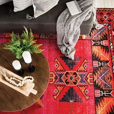 a living room with a couch, coffee table and rugs on the floor in front of it