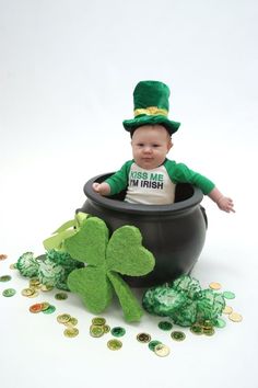 a baby is sitting in a pot with shamrocks