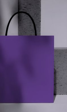 a purple shopping bag sitting on top of a counter next to a white brick wall