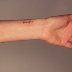 a person's arm with a small tattoo on the wrist that says be brave