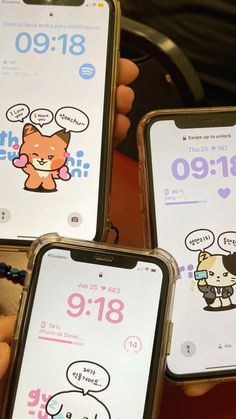 three cell phones with cartoon stickers on their screens and the same one being held by someone's hand