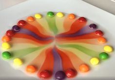 there is a cake decorated with candies on the plate and icing in the shape of a circle