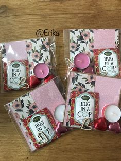 three packages of pink candles sitting on top of a wooden table