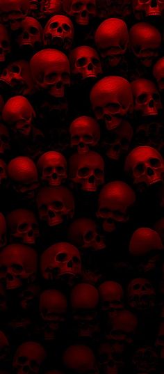 a bunch of skulls that are all red and black in the dark, with only one skull visible