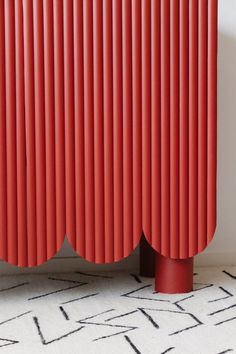 a red piece of furniture sitting on top of a white rug