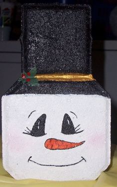 a close up of a box with a face painted on the side and a gold trim around the top