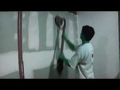 a man is painting the wall with white paint