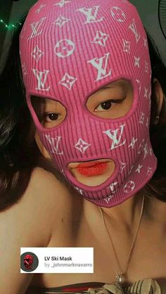 a woman wearing a pink mask with louis vuitton on it's face