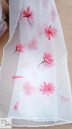 pink flowers are painted on white sheer fabric