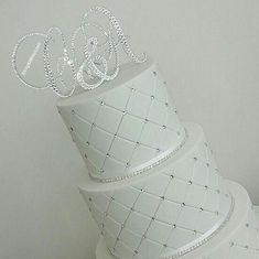 three tiered wedding cake with white icing and crystal monogrammed letters on top