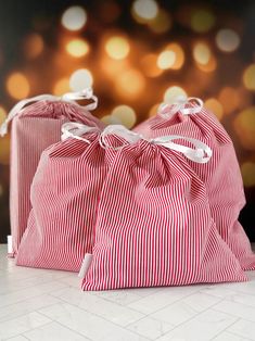 two red and white striped bags sitting next to each other on top of a table