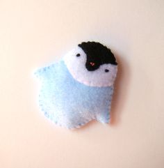 a small blue and white bird brooch with black eyes on it's back