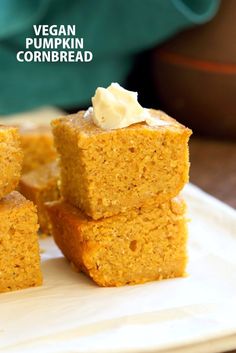 vegan pumpkin cornbread squares stacked on top of each other with cream in the middle