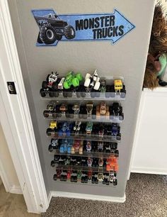 there is a monster truck display on the wall in front of a door that says monster trucks