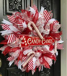 a candy cane wreath is hanging on the front door for someone's christmas decor