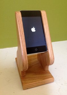 an iphone in a wooden stand on a table