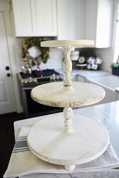 three tiered cake stand sitting on top of a kitchen counter