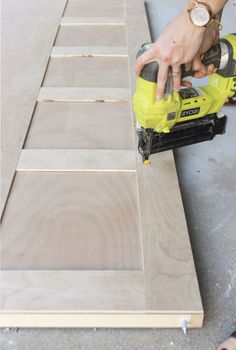 a person using a power drill to cut plywood